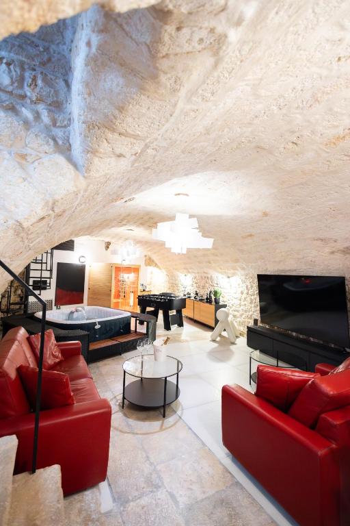 a living room with red furniture and a stone wall at Dimora San Rocco in Molfetta