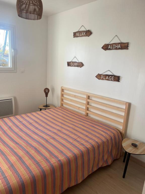 a bedroom with a bed and signs on the wall at Magnifique maison neuve Mimizan plage proche océan in Mimizan-Plage