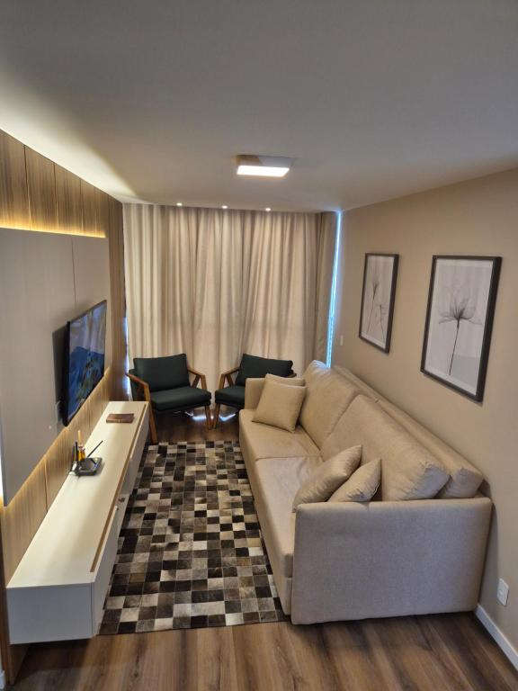 a living room with a couch and a tv at Luxo e Lazer Apto 2Qtos 1 Suíte AC e Rooftop in Belém