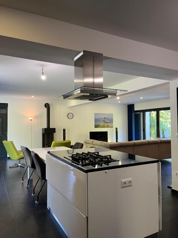 a kitchen with a stove top oven next to a living room at Villa Bukvic in Zavidovići