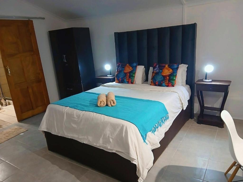 a bedroom with a bed with two towels on it at Aero Garden Ensuite in Johannesburg