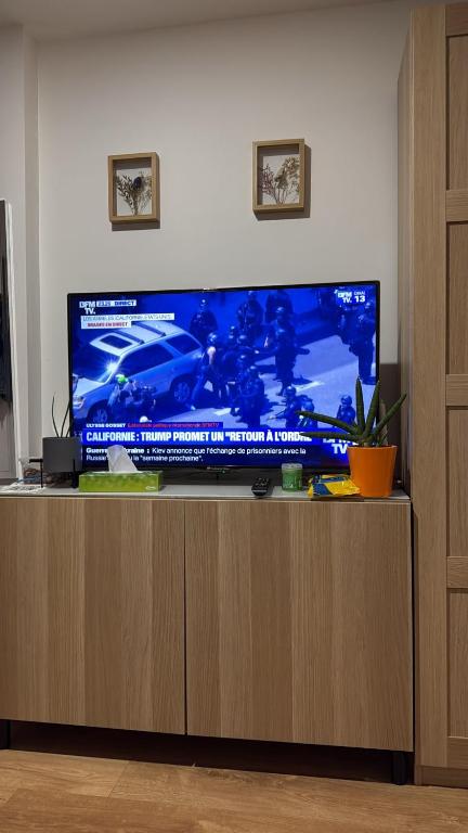 a flat screen tv sitting on top of a wooden cabinet at Paris studio in Villeneuve-la-Garenne