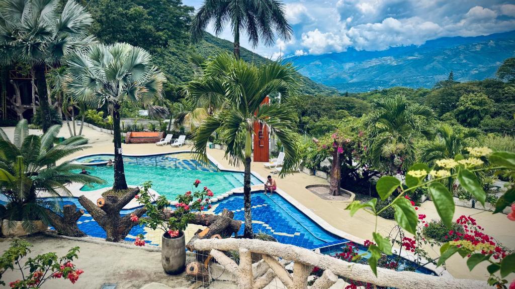 een resortzwembad met palmbomen en een berg bij Solvae EcoHotel in San Jerónimo