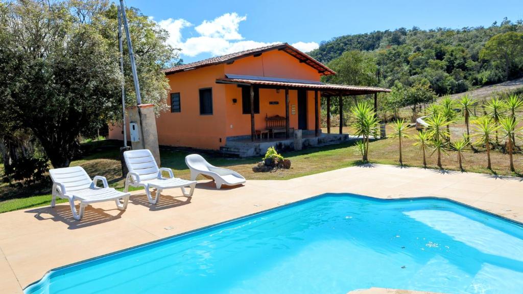 a house with a swimming pool in front of a house at Canto das Árvores - Nova União MG in União de Caeté