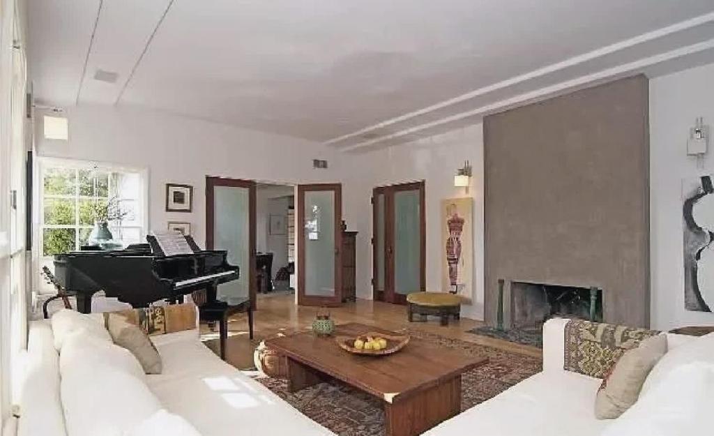 een woonkamer met een piano en een witte bank bij Tranquil 3 Bedroom Home in Santa Monica Canyon in Los Angeles