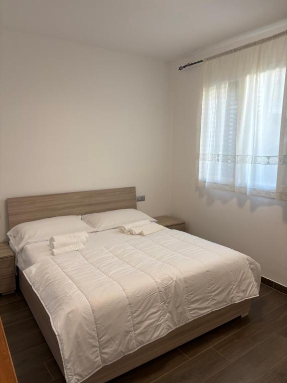 a white bed in a bedroom with a window at Luino Family Retreat in Luino