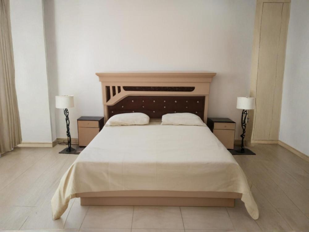 a bedroom with a large white bed with two lamps at السعادة للشقق المفروشة 