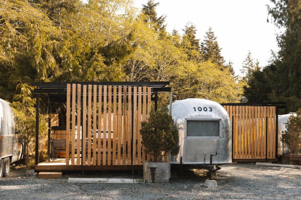 an old rv parked next to a wooden fence at Mackenzie Beach Resort in Tofino