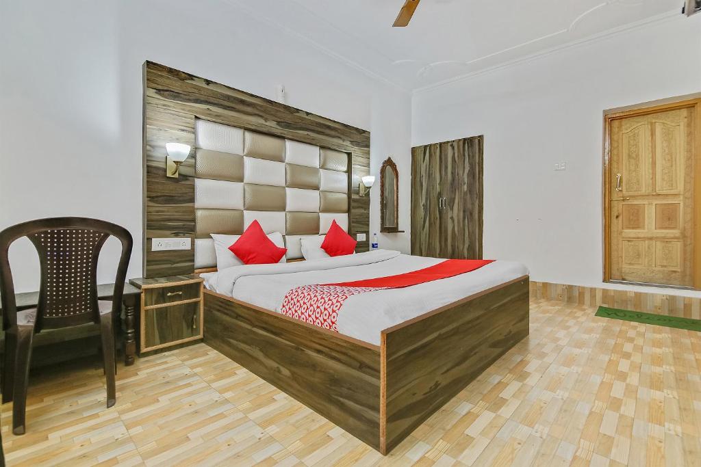 a bedroom with a large bed with red pillows at Hotel O Hameed in Durgjan