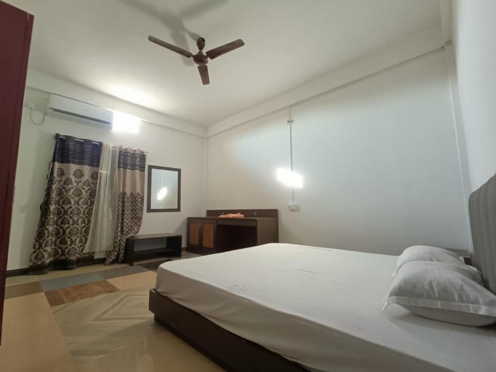 a bedroom with a bed and a ceiling fan at Saagar's Farmstay in Jalpāiguri
