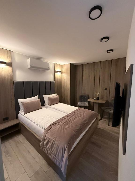 een slaapkamer met een groot bed en een tv bij Casa ARTEE Free Parking in Sarajevo