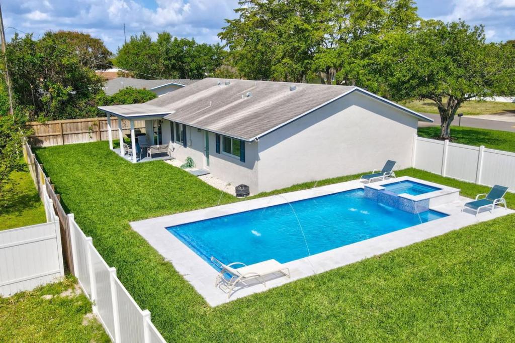 a backyard with a swimming pool and a house at Delray Oasis Pool Hot Tub in Tropic Isle