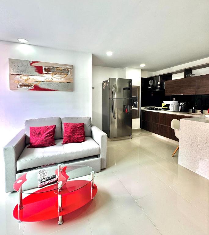 a living room with a couch and a kitchen at Apartamento Ideal y Tranquilo in Sabaneta
