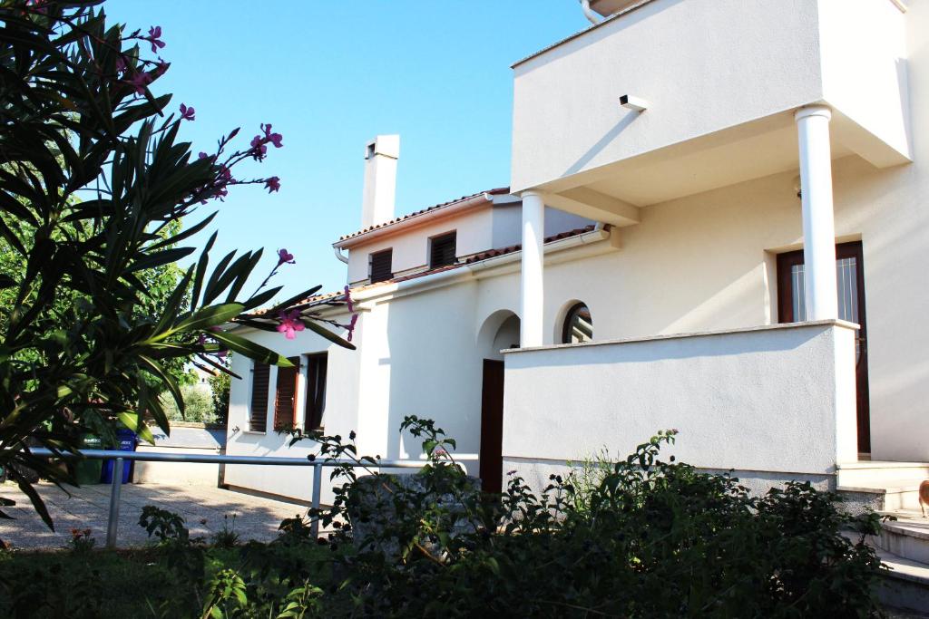 una casa blanca con una valla delante en Apartments Cavae Romanae, en Medulin