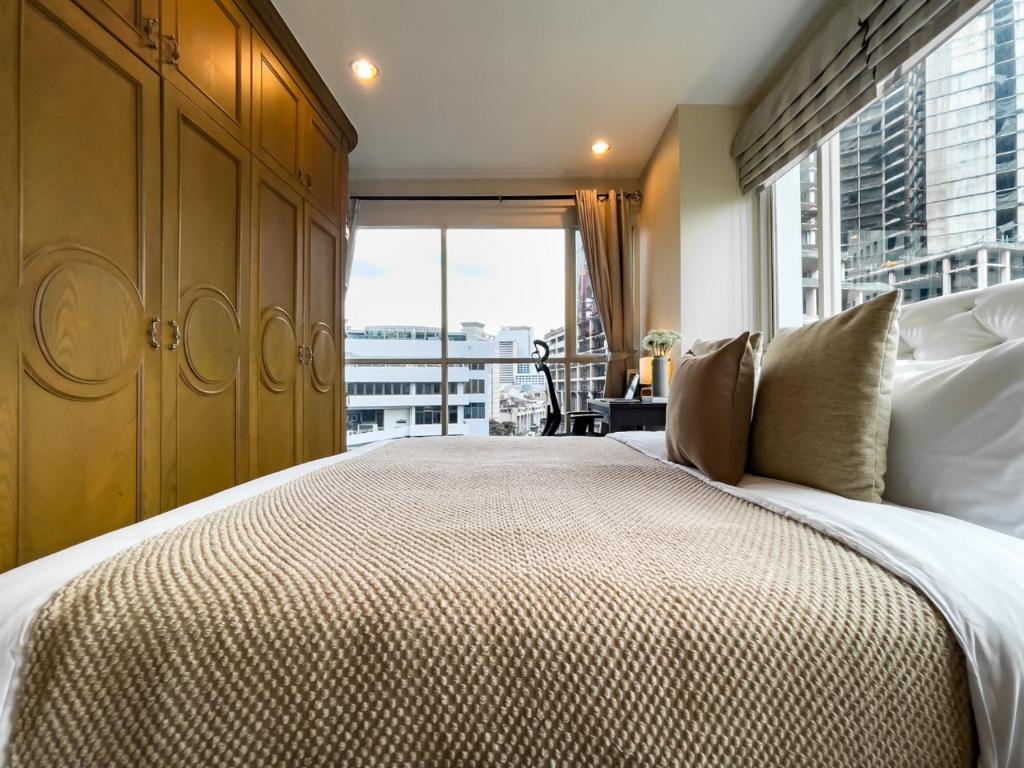 Un dormitorio con una cama grande con una ventana grande. en 300m BTS l Large 110 sqm l Pool and Sauna, en Makkasan