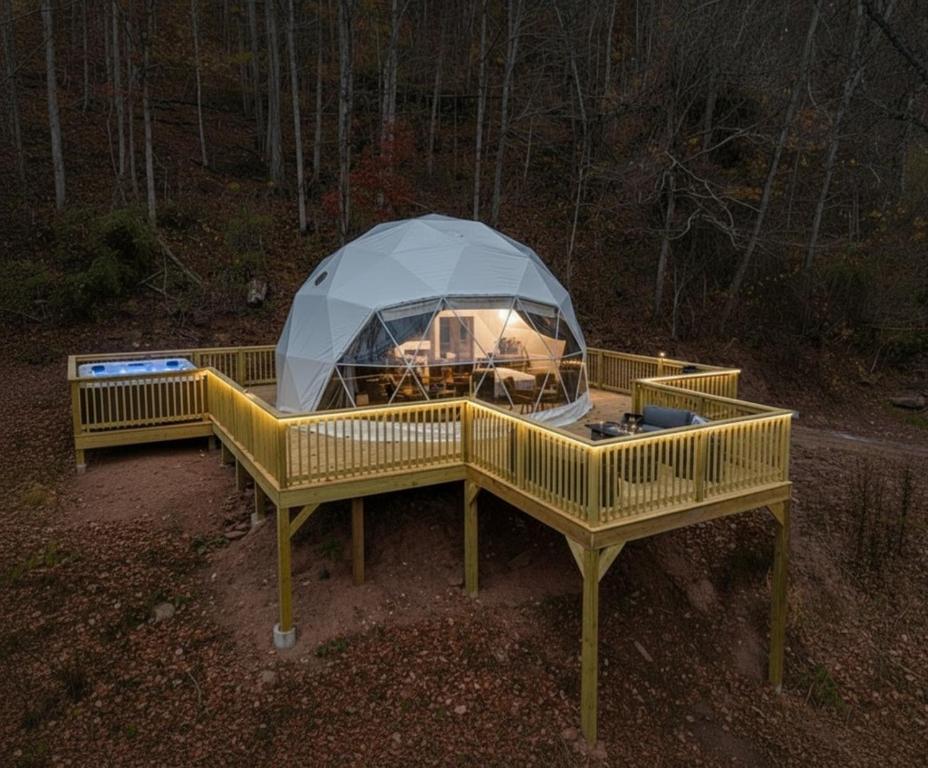 a tent is set up in the woods at night at Once-in-a-Lifetime Escape Celestine Hot Tub Between Two State Parks in Pipestem