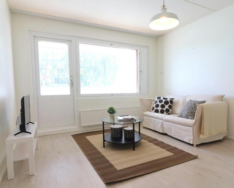 a living room with a couch and a table at Central and Spacious Apartment for 4 with Sauna in Kirkkonummi