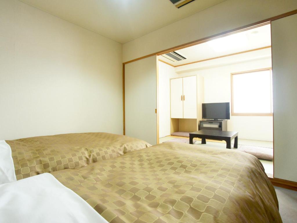 Postel nebo postele na pokoji v ubytování Hotel Trend Nagano