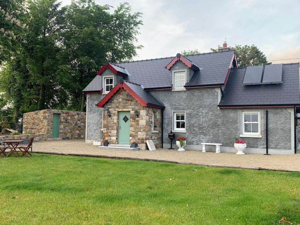 a stone house with a green door and a bench at Paul's country cottage in Donegal