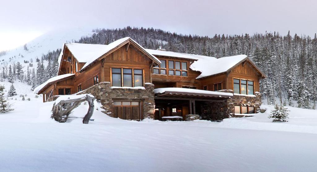 a log cabin in the snow with snow at Blue Moon Challet in Big Sky Mountain Village