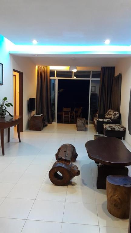 a living room with a wooden table and a table at Rose Apartment Kea Farm in Cameron Highlands