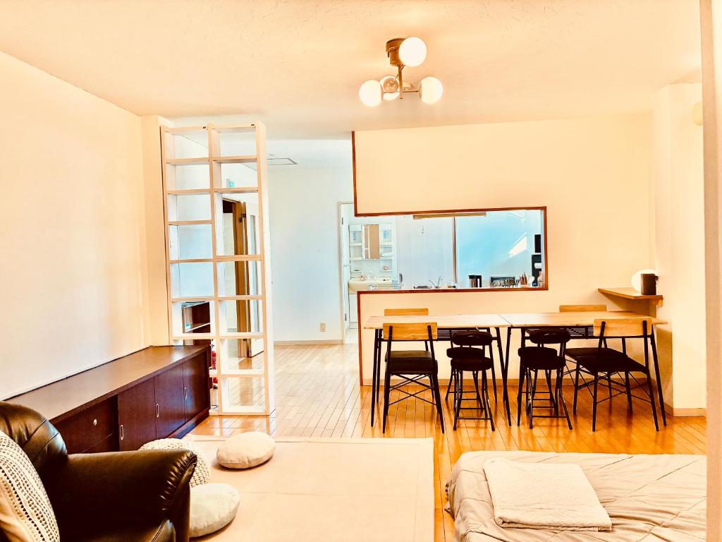 Una sala de estar con mesa de comedor y sillas. en バス停"平城札所前"徒歩0分 四国愛媛の宿 "40番たっきゅうミニホテル" "No40 Takkyu mini hotel", en Hirajō
