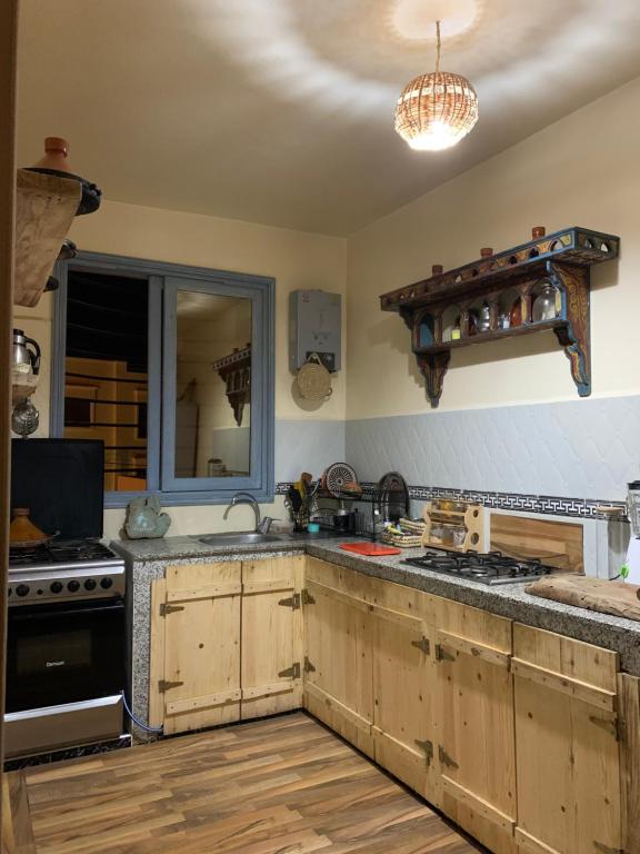 una cocina con fregadero y estufa horno superior en The FlowHost, en Tamraght Ouzdar