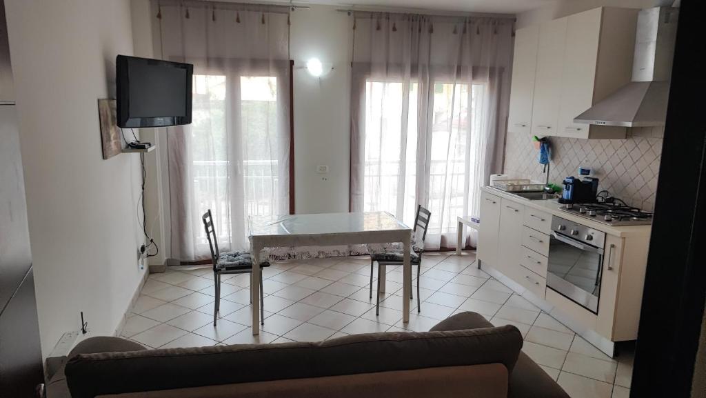 Una sala de estar con una mesa y una cocina. en Holiday House Iolo, en Prato