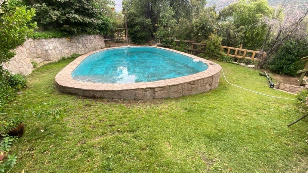 a swimming pool in a yard with a grassy field at Luna del maipo in El Ingenio