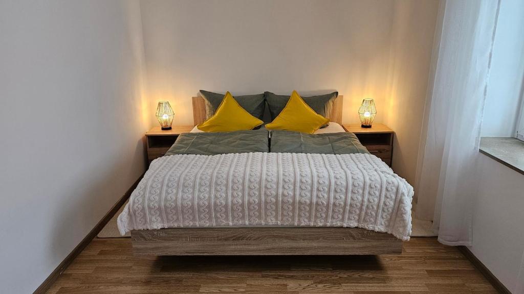 Un dormitorio con una cama grande con almohadas amarillas. en Gemütliche zwei Zimmer Wohnung am Rhein, en Weißenthurm