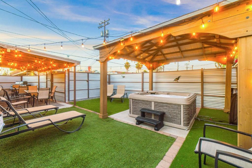 un patio con parrilla, mesas y sillas en Mins from the UofA & Downtown 4BR 2BA Entire Home, en Tucson