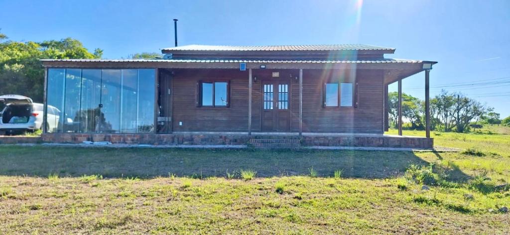 ein kleines Haus mit Glasfassade auf einem Feld in der Unterkunft Rancho Bela Vista - o seu recanto em Pelotas in Pelotas