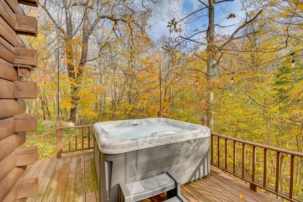 a hot tub on a deck in the woods at Private Yard Secluded Hannibal Cabin in the Pines in Fulton