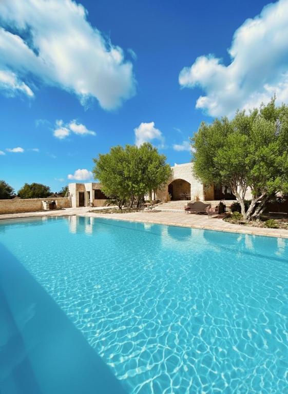 una piscina azul con una casa en el fondo en Villa à Essaouira, en Essaouira