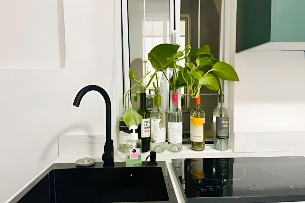a kitchen counter with bottles of wine and a sink at 02-Hermoso apt en el centro de mty in Monterrey