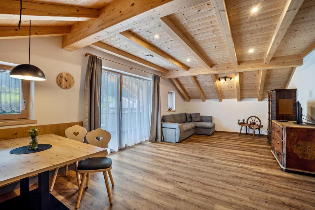 sala de estar con techo de madera y mesa en Krämerhof Apt Aferer Geisler, en Rodengo