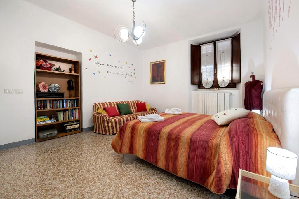 イゼーオにあるCasa vacanze da rosaのベッドとソファのある寝室