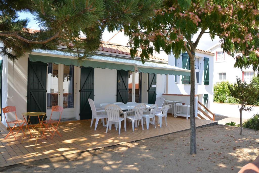 a patio with a table and chairs on a house at Les Floralies in La Tranche-sur-Mer