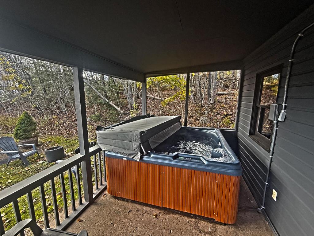 a grill sitting on a screened in porch at Private Hot tub new 2 Bedroom Home in Catskills in Elka Park