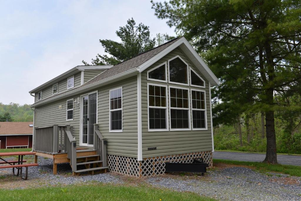 a tiny house with a porch and a bench at Hershey Camping Resort Loft Park Model 7 in Mount Wilson