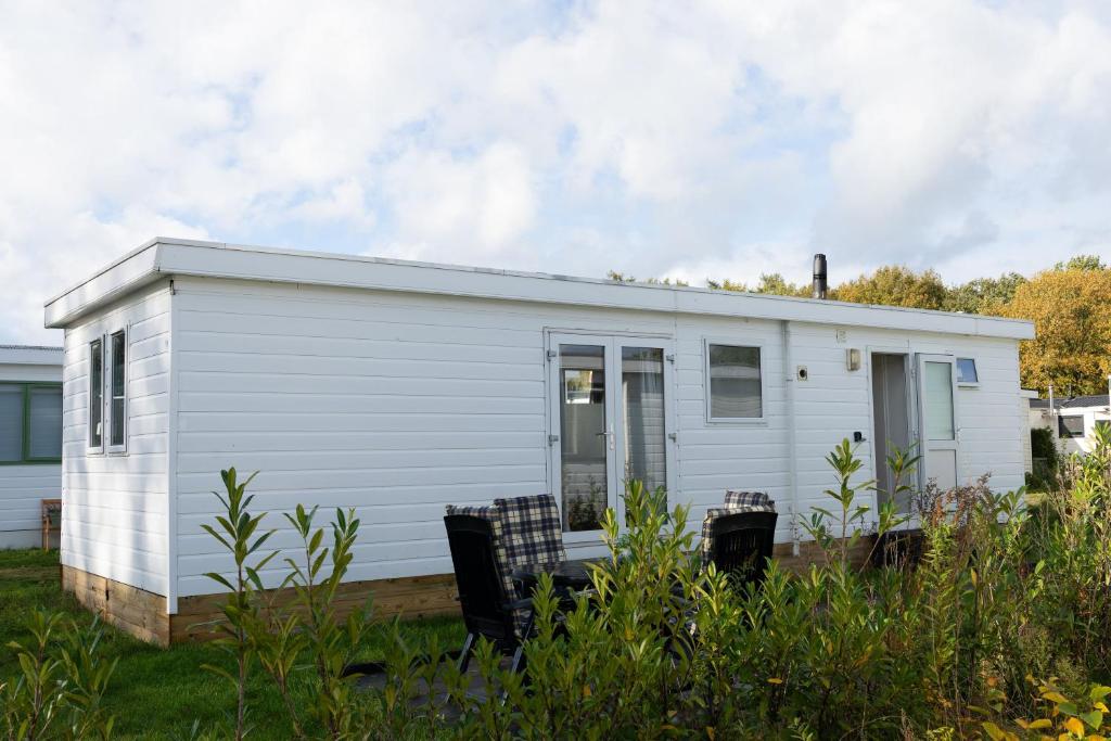 a white tiny house in a yard at Chalet Koolmees in Anloo
