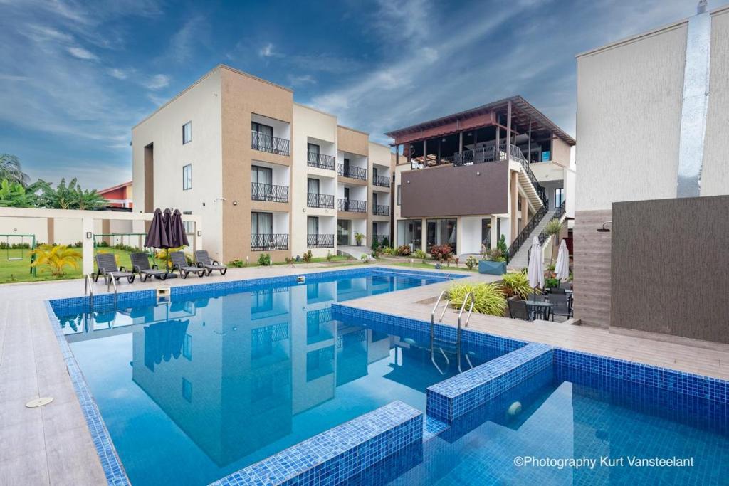 KoforiduaにあるAIDEN HOMES AND APARTMENTS HOTElの建物の前のプール