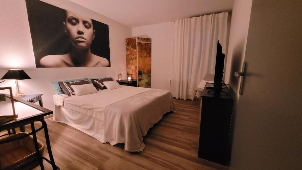 a bedroom with a bed and a poster of a woman at Résidence Les Salines in Villeneuve-lès-Maguelonne