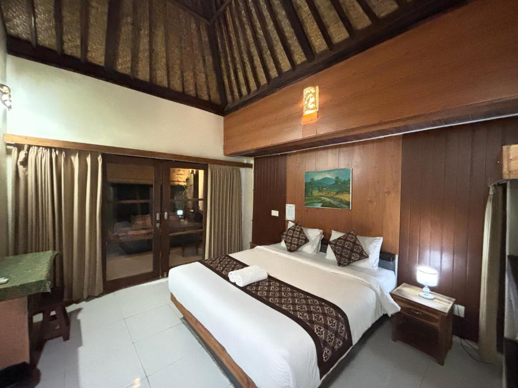 sypialnia z 2 łóżkami i biurkiem w obiekcie Pomelo Guest House w mieście Ubud