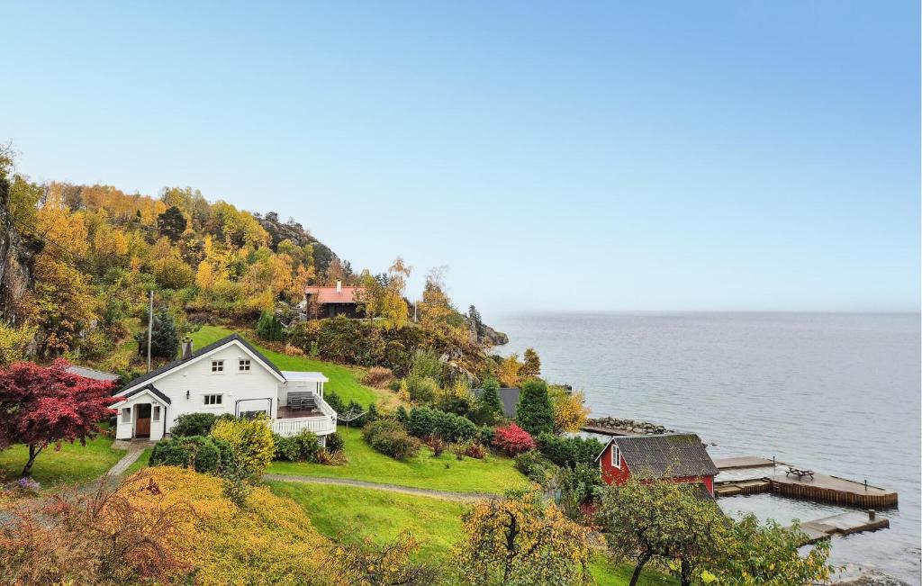 a house on a hill next to the water at Awesome Home In Skiftun With House Sea View in Nesvik