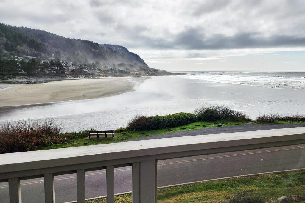 a bench sitting on the side of a beach at Oceanfront Views! Hot Tub! Starlit Shores in Yachats