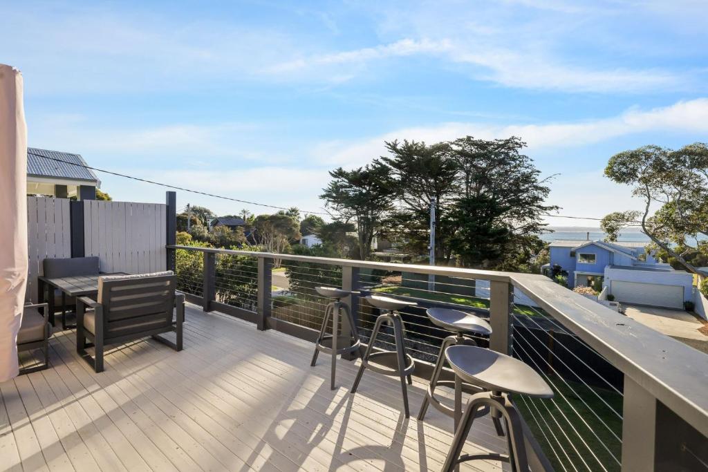 een balkon met een tafel en stoelen en de oceaan bij Seahaven Views in Ventnor