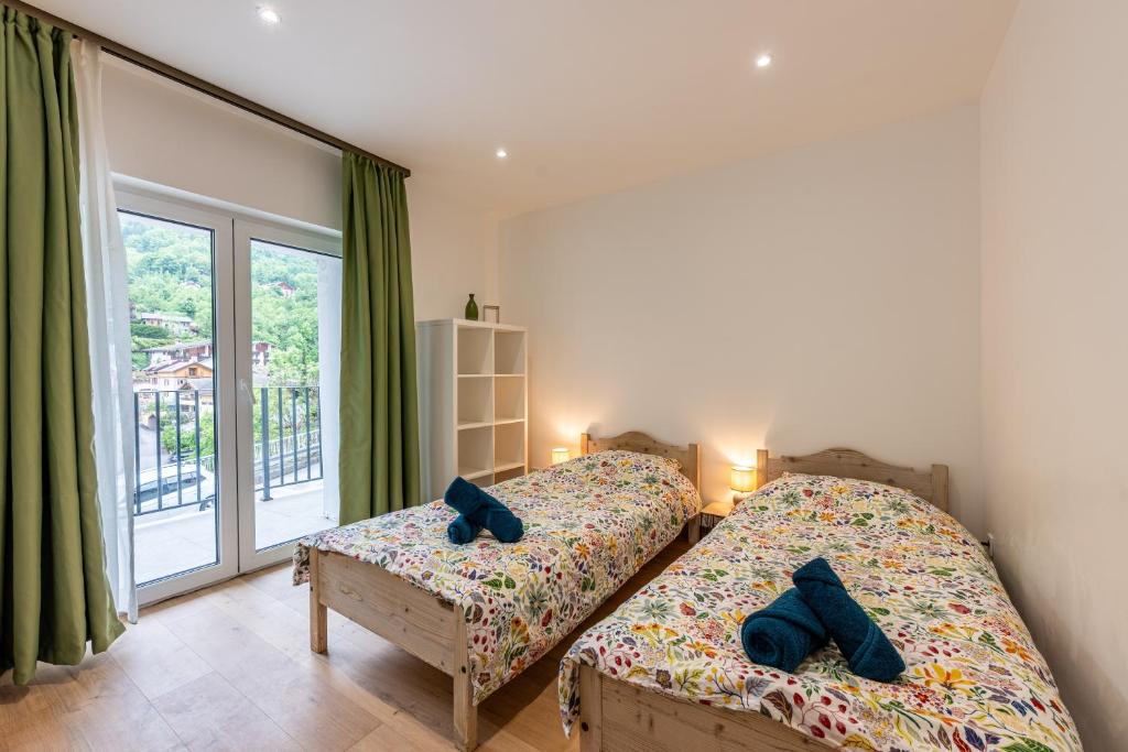 Un dormitorio con dos camas y una gran ventana. en Villa la source, en Brides-les-Bains