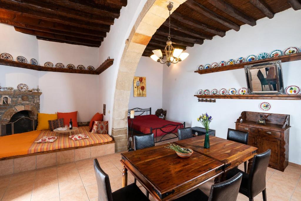 a living room with a wooden table and a couch at 1900s traditional house in Asklipio in Asklipiḯon