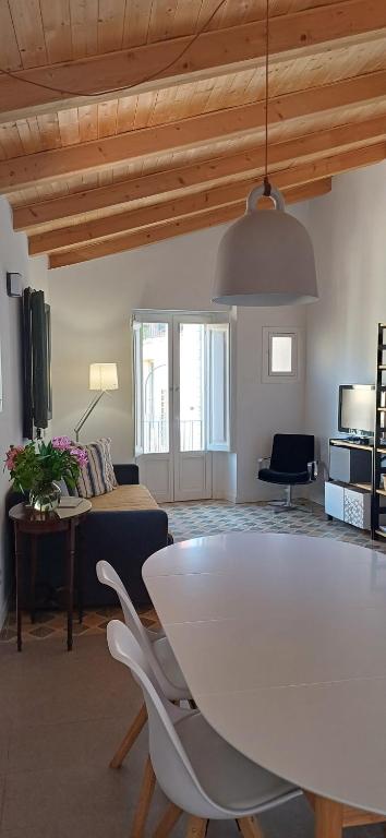 a living room with a white table and a couch at FeelhomeVIC. Ático con terraza en centro histórico in Vic